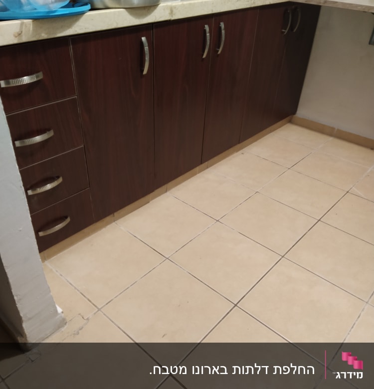 ארונות מטבח עם ידיות מתכת על רצפת קרמיקה